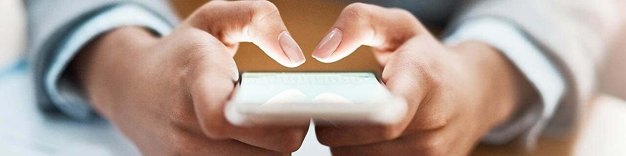 Two hands shown using a mobile device to send an email
