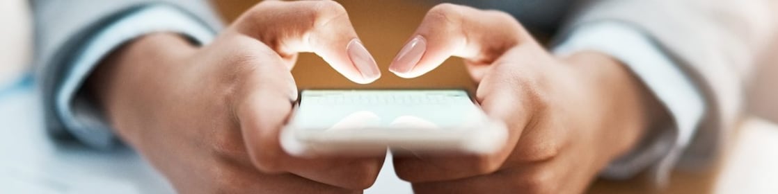 Two hands shown using a mobile device to send an email