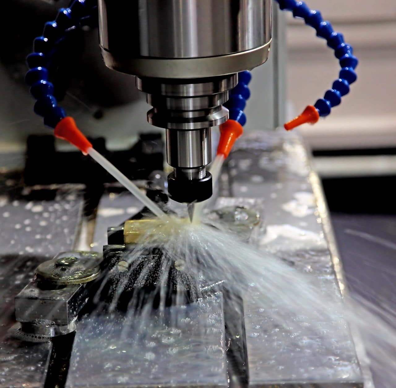 An oil drill being worked, and water being pumped onto it to help cool it down