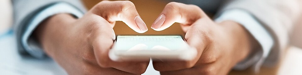 Two hands shown using a mobile device to send an email