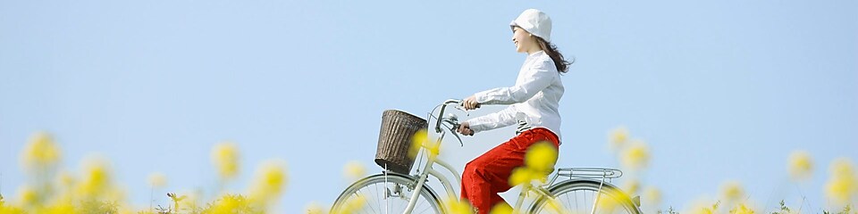 여름 들판을 자전거를 타고 달리는 젊은 여성