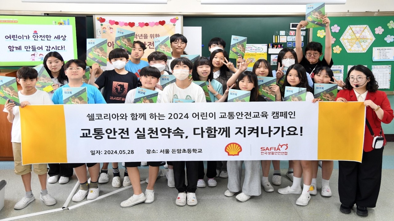  [사진1] 지난 28일 쉘코리아 2024 '아동교통안전교육 캠페인' 첫 수업에 참여한 서울 돈암초등학교 6학년 6반 학생들과 캠페인 지도교사가 워크북을 들고 기념사진을 촬영하고 있다.