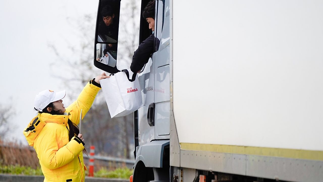 ‘리무라 졸음운전 방지 캠페인’행사 관계자가 대형 트럭 운전자에게 안전 패키지를 전달하고 있다. 